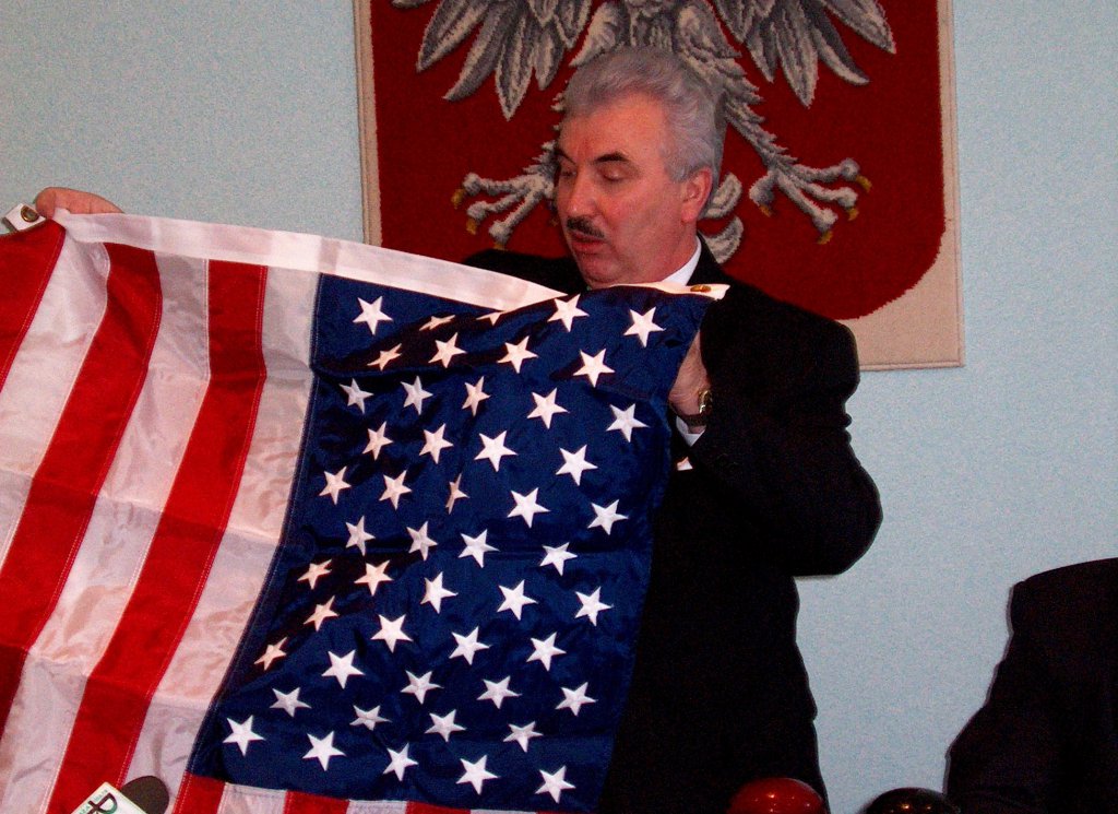 Prezydent Ryszard Załuska z flagą USA, kt&oacute;rą przywi&oacute;zł z wyprawy